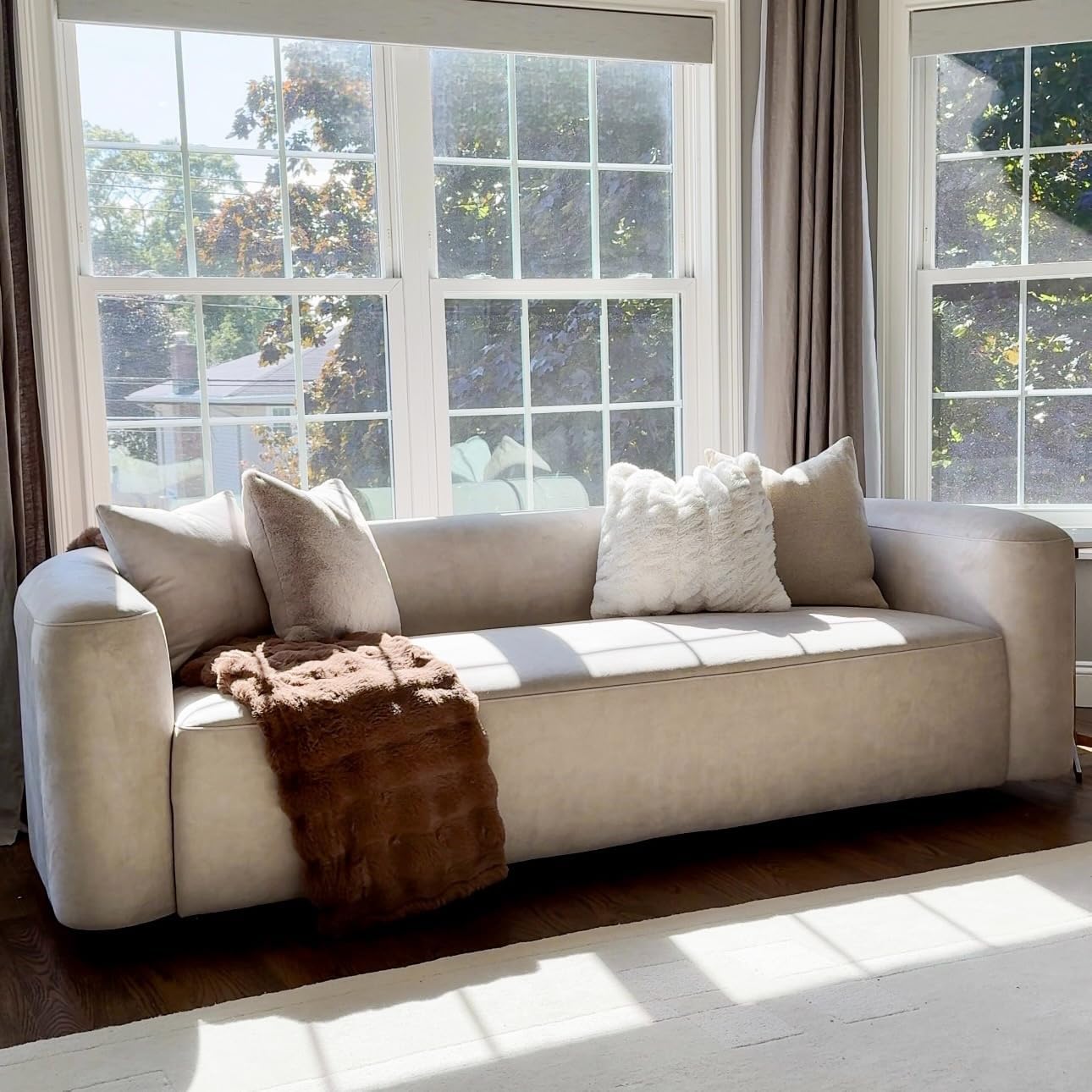 Modern 3-seater velvet sofa with curved back in neutral tone, wood frame detail — view 3