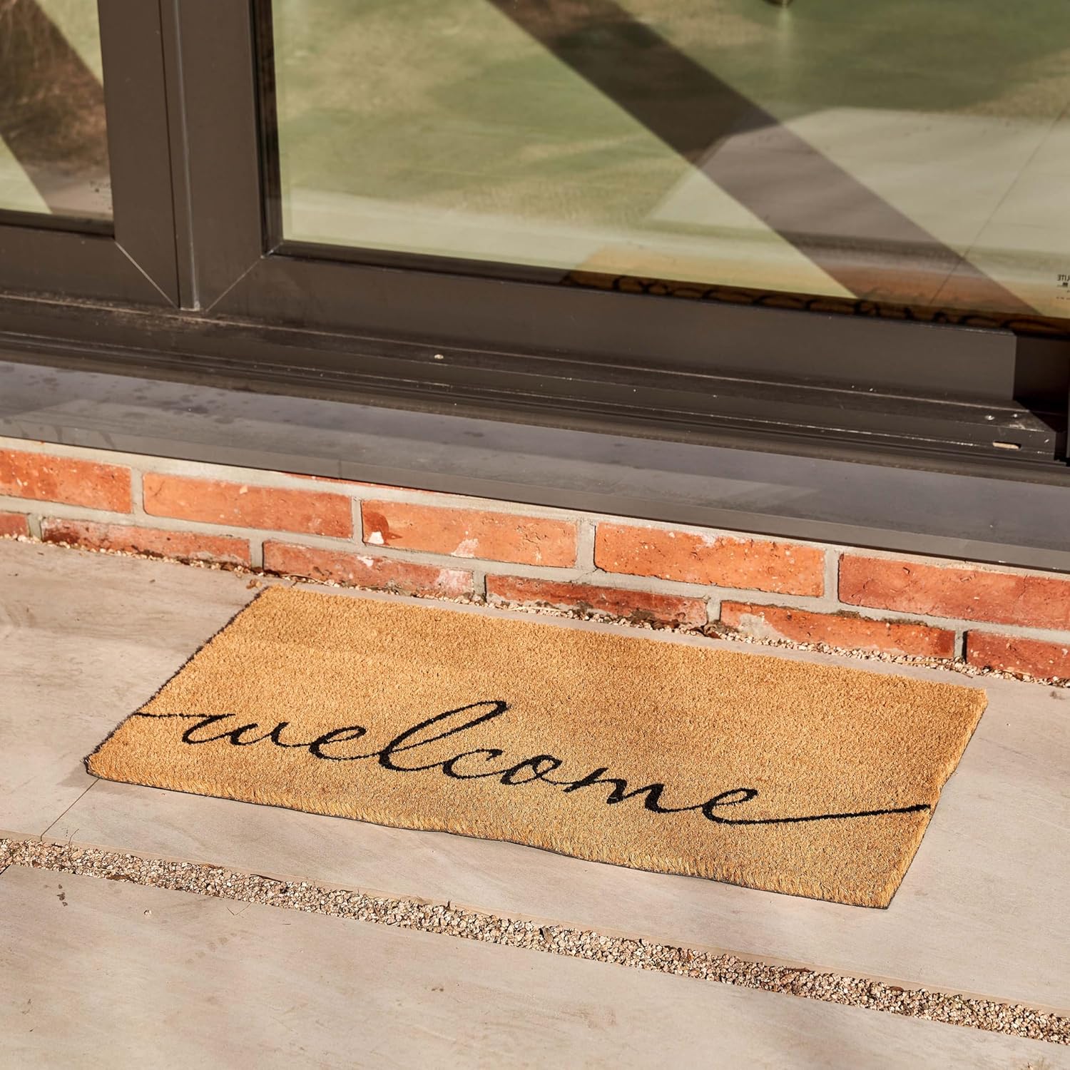 Rectangular coco coir door mat with rubber backing in neutral tone, shown at entryway entrance — view 2