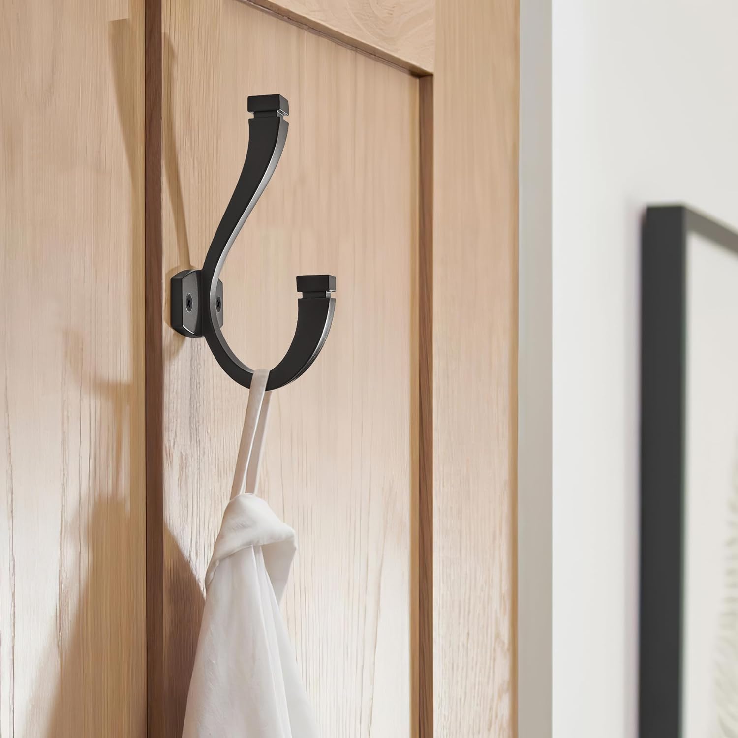 Matte black metal double wall hook with minimalist design, shown mounted on white wall — view 4