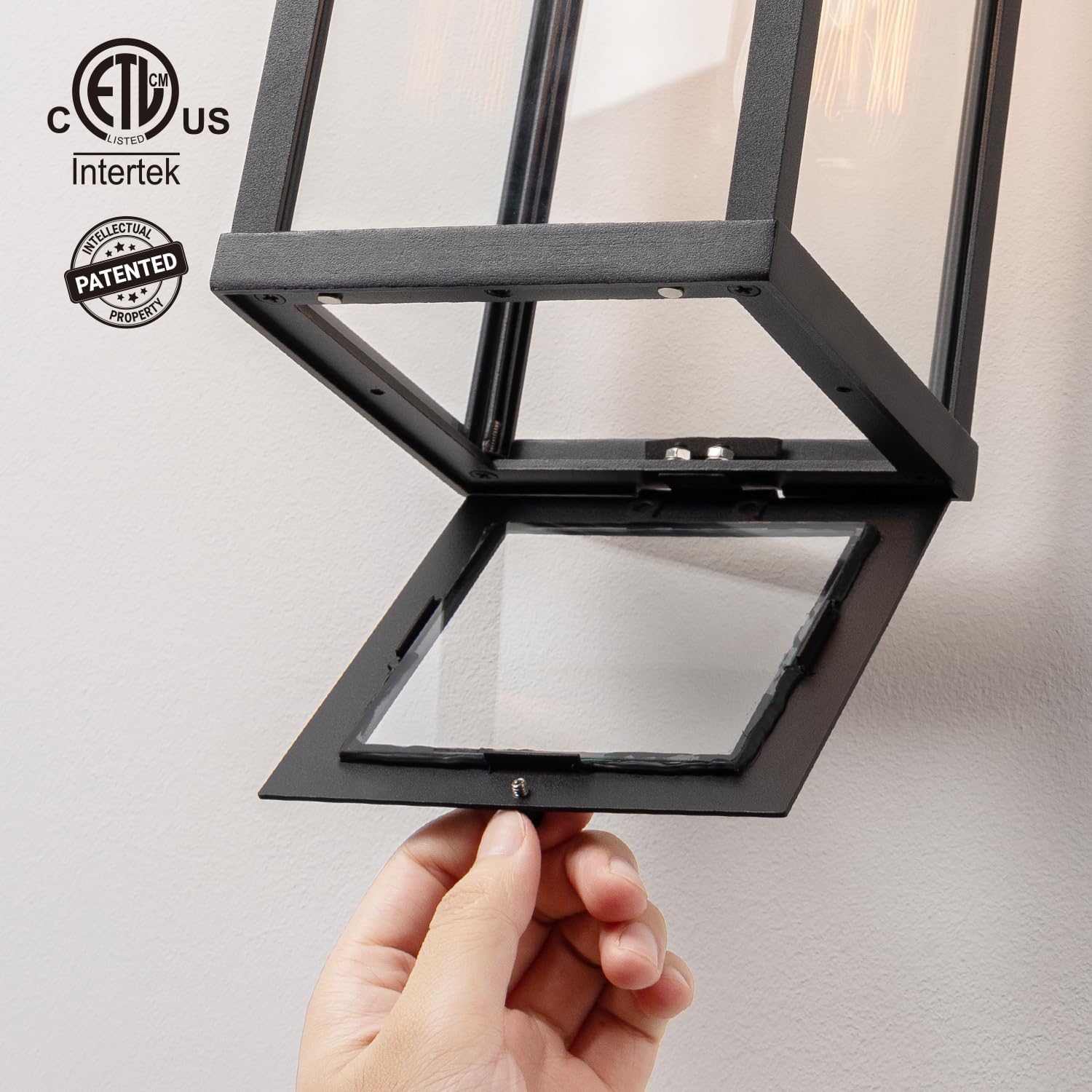 Matte black metal rectangular outdoor wall sconce with clear glass shade, shown mounted on porch exterior — side
