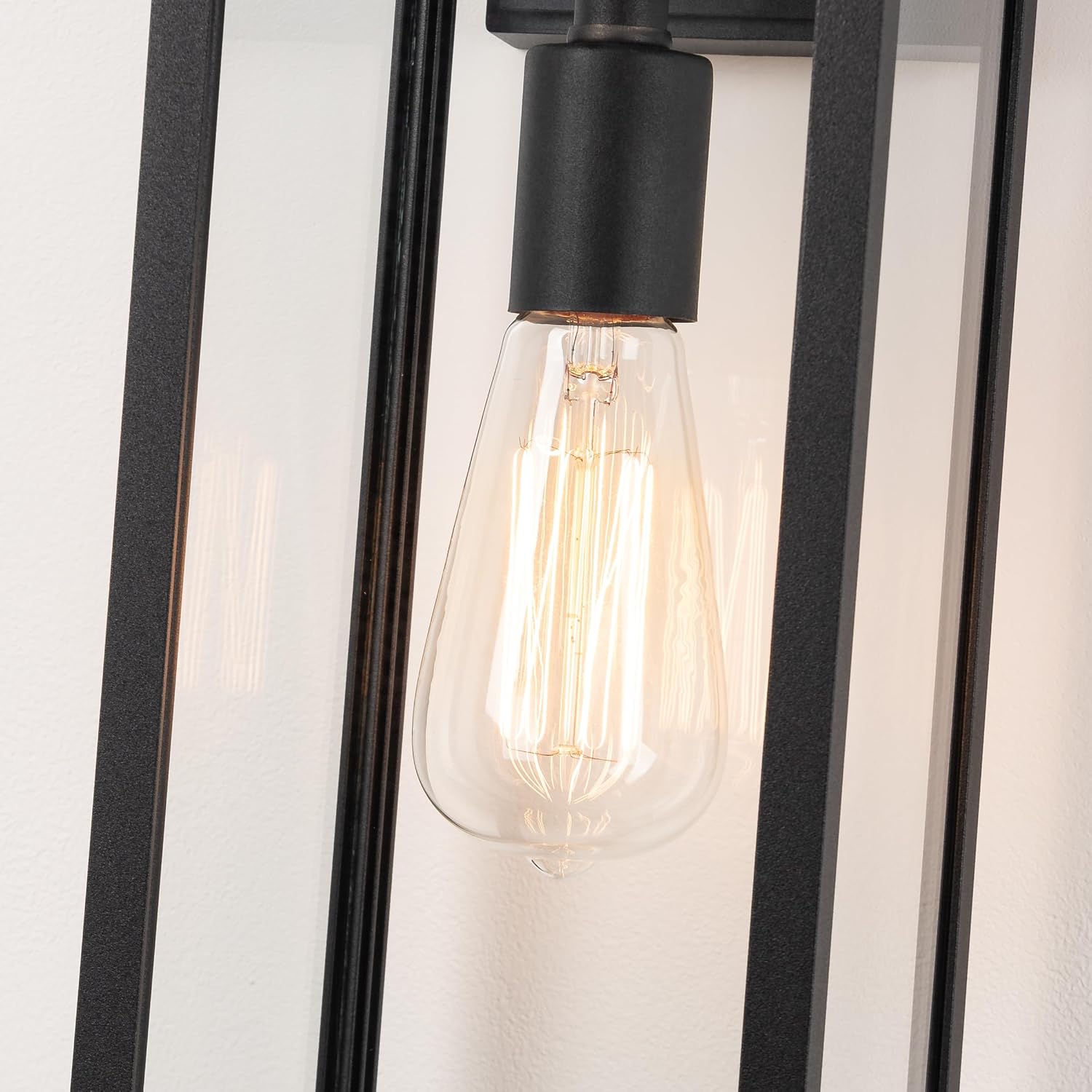 Matte black metal rectangular outdoor wall sconce with clear glass shade, shown mounted on porch exterior — view 4