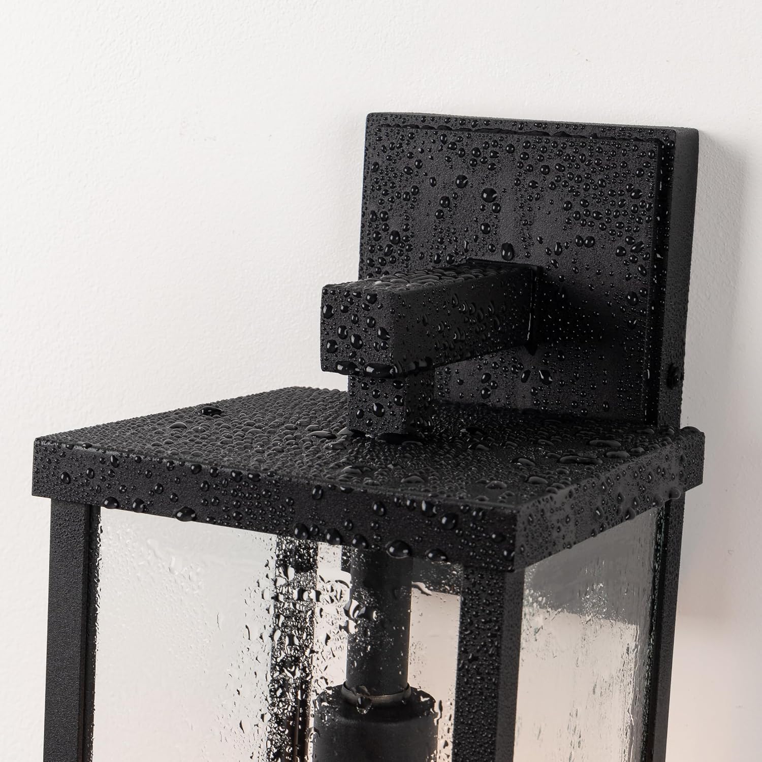 Matte black metal rectangular outdoor wall sconce with clear glass shade, shown mounted on porch exterior — view 5