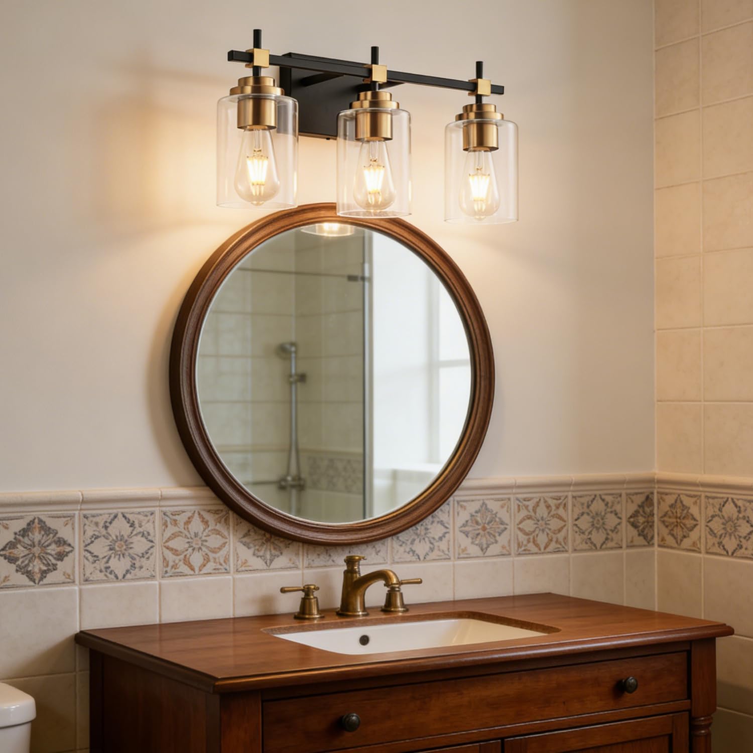 Black metal vanity light fixture with brass accents and clear glass shades for bathroom mirror installation — view 4