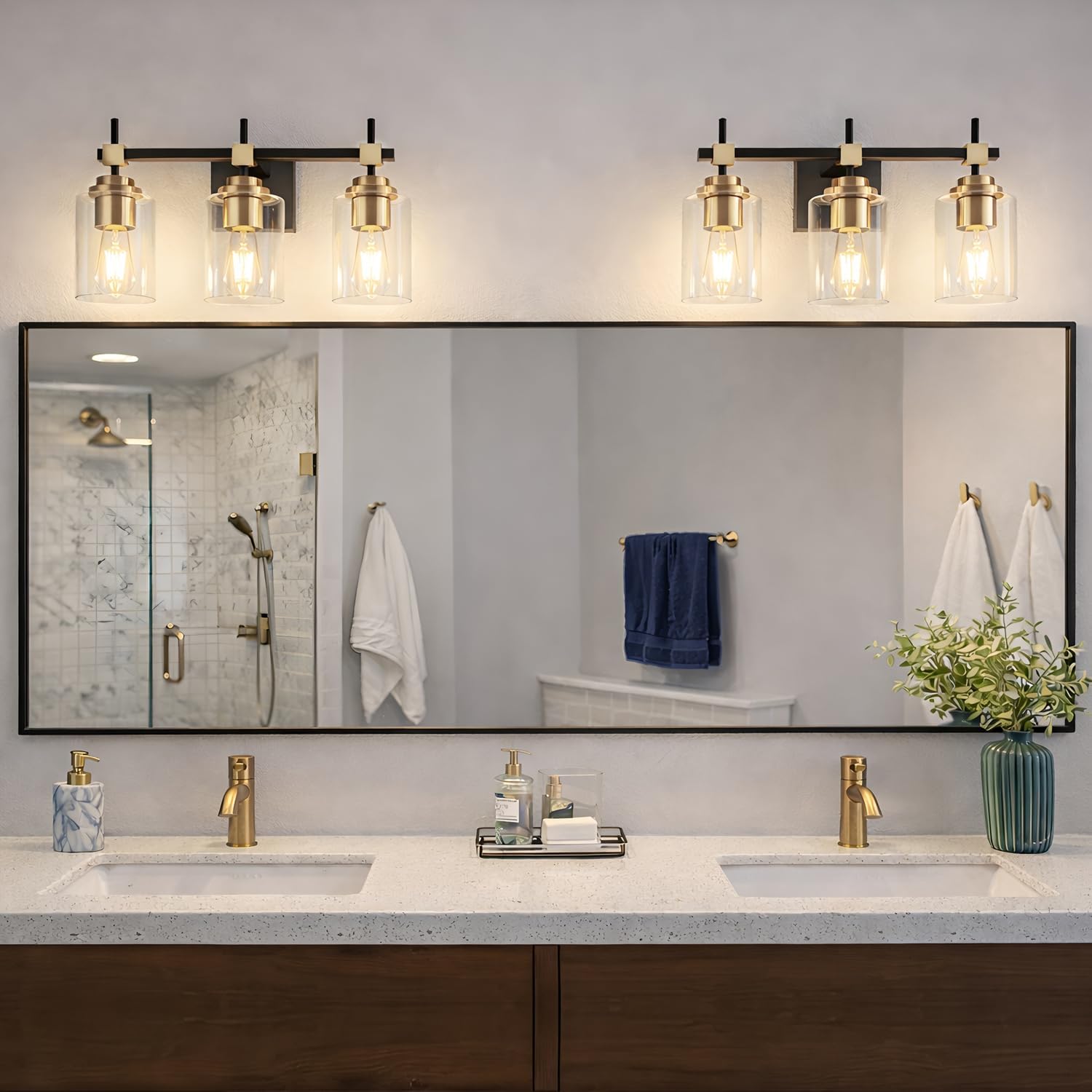 Black metal vanity light fixture with brass accents and clear glass shades for bathroom mirror installation — view 5