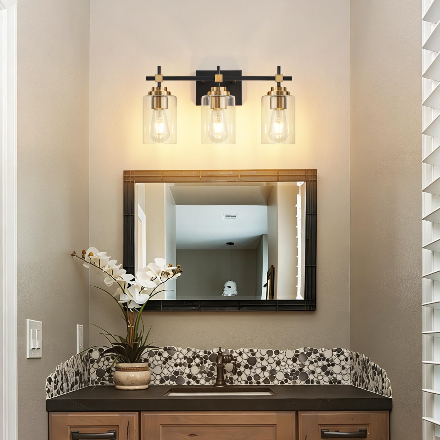 Black metal vanity light fixture with brass accents and clear glass shades for bathroom mirror installation — view 5b